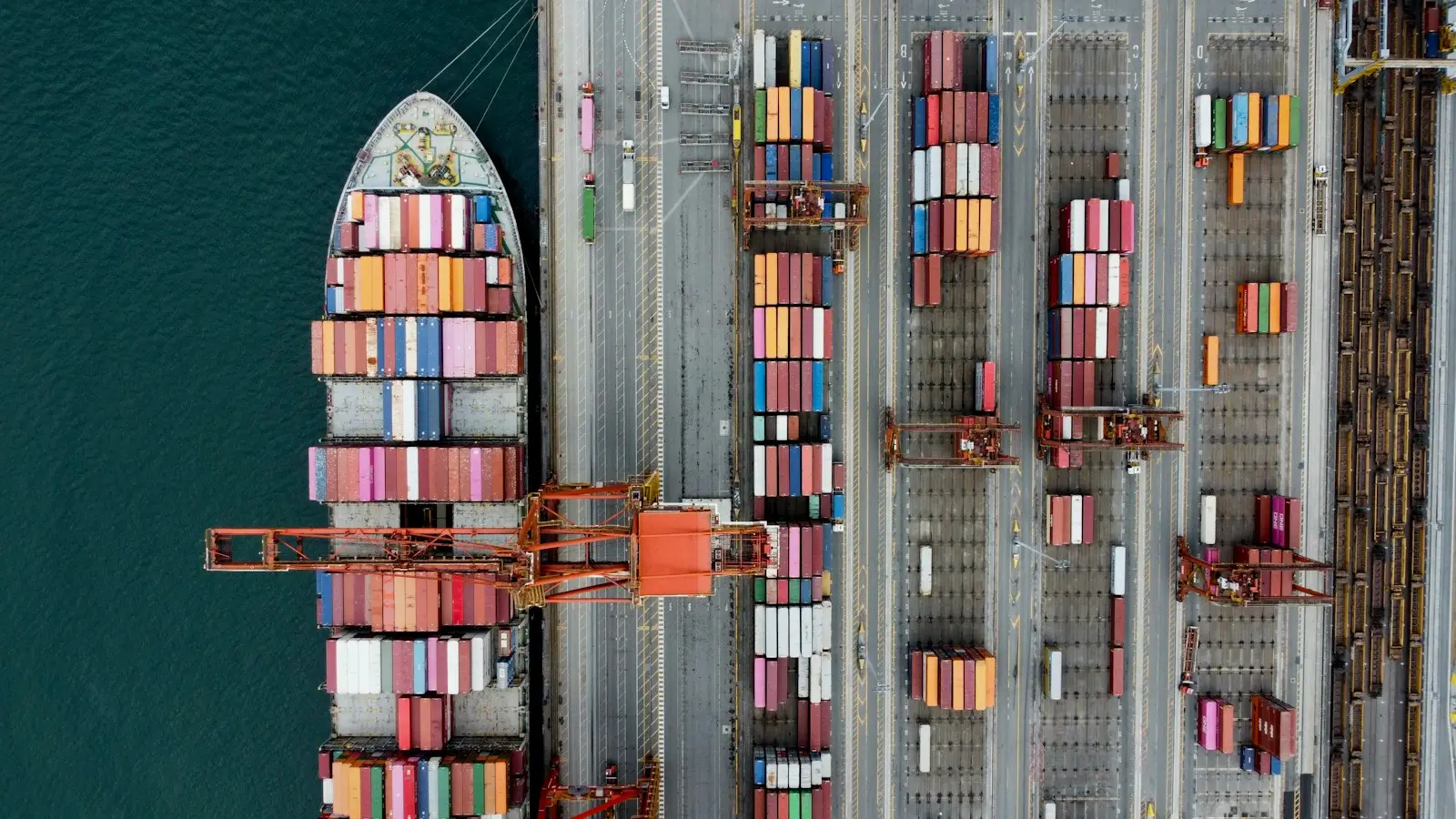 Vista aérea de un buque y contenedores en un puerto; fotografía de referencia del sector.